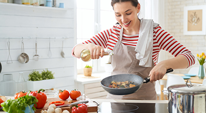 Frau beim Kochen am AEG Kochfeld